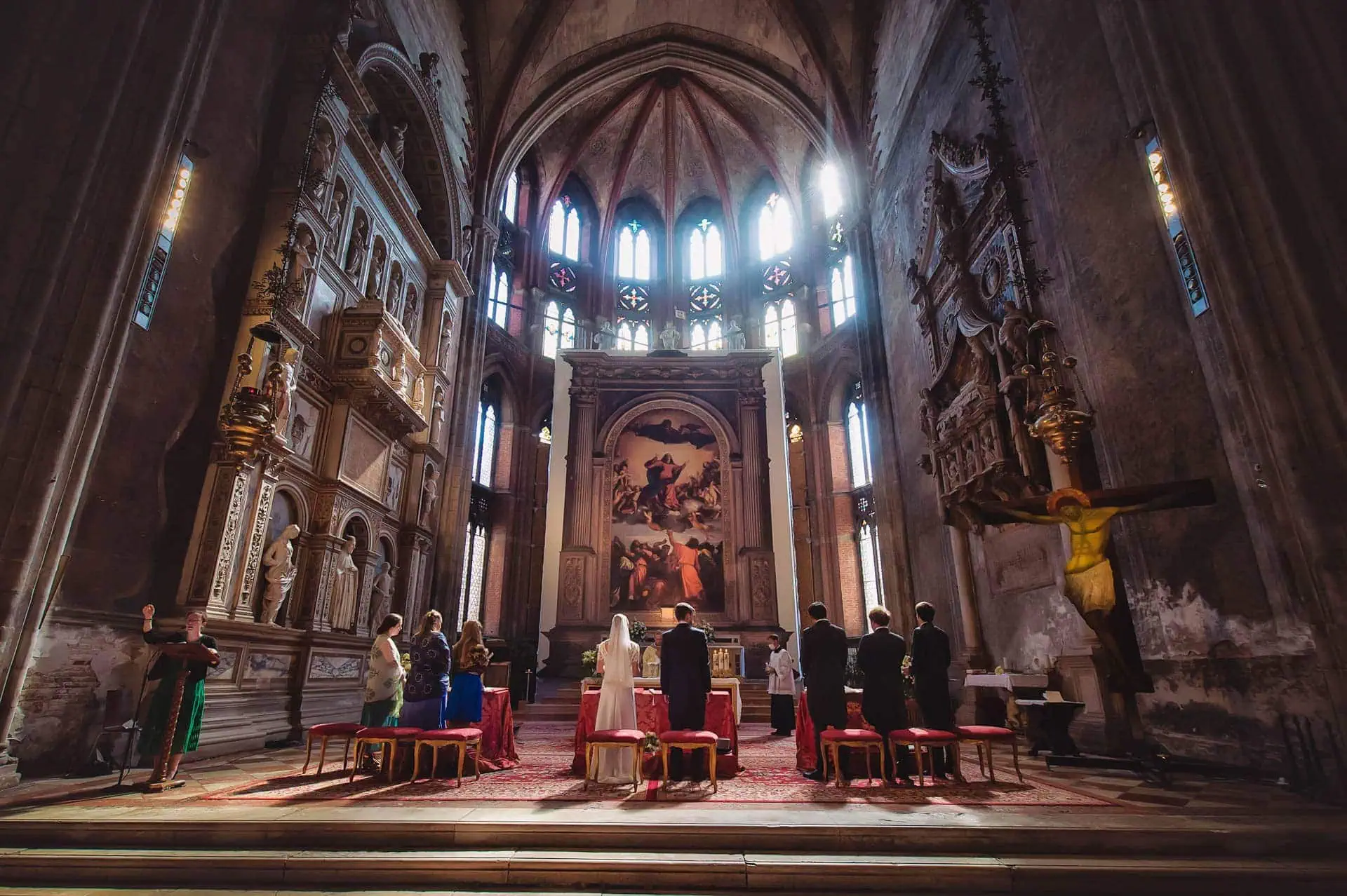 Venice wedding ceremony inside historic church with altar and religious icons.