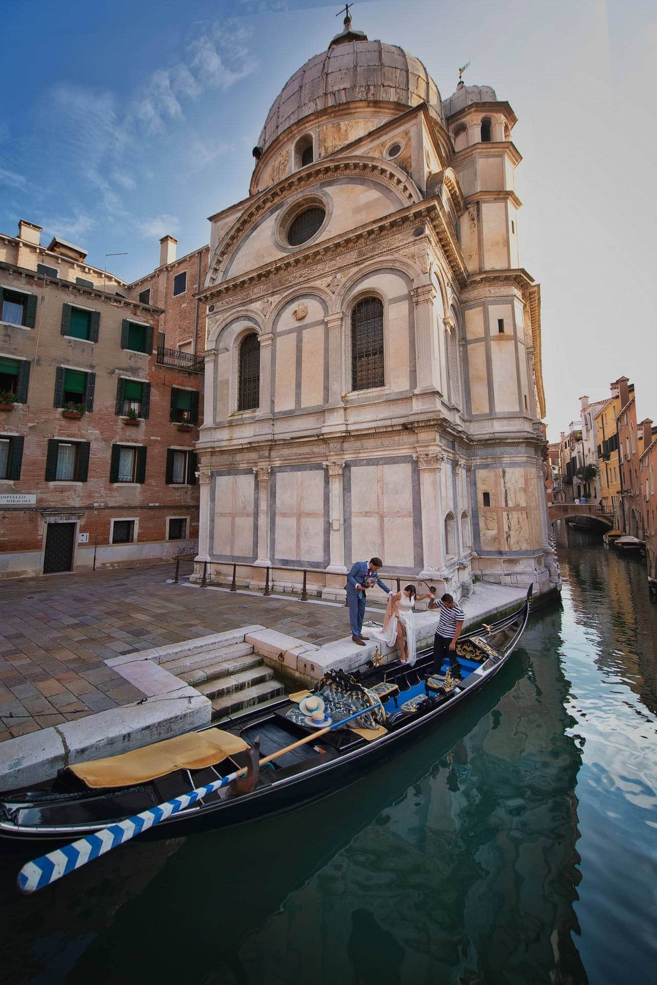 Venice wedding proposal on a gondola near a historic church, capturing romantic moments in Venice, Italy.