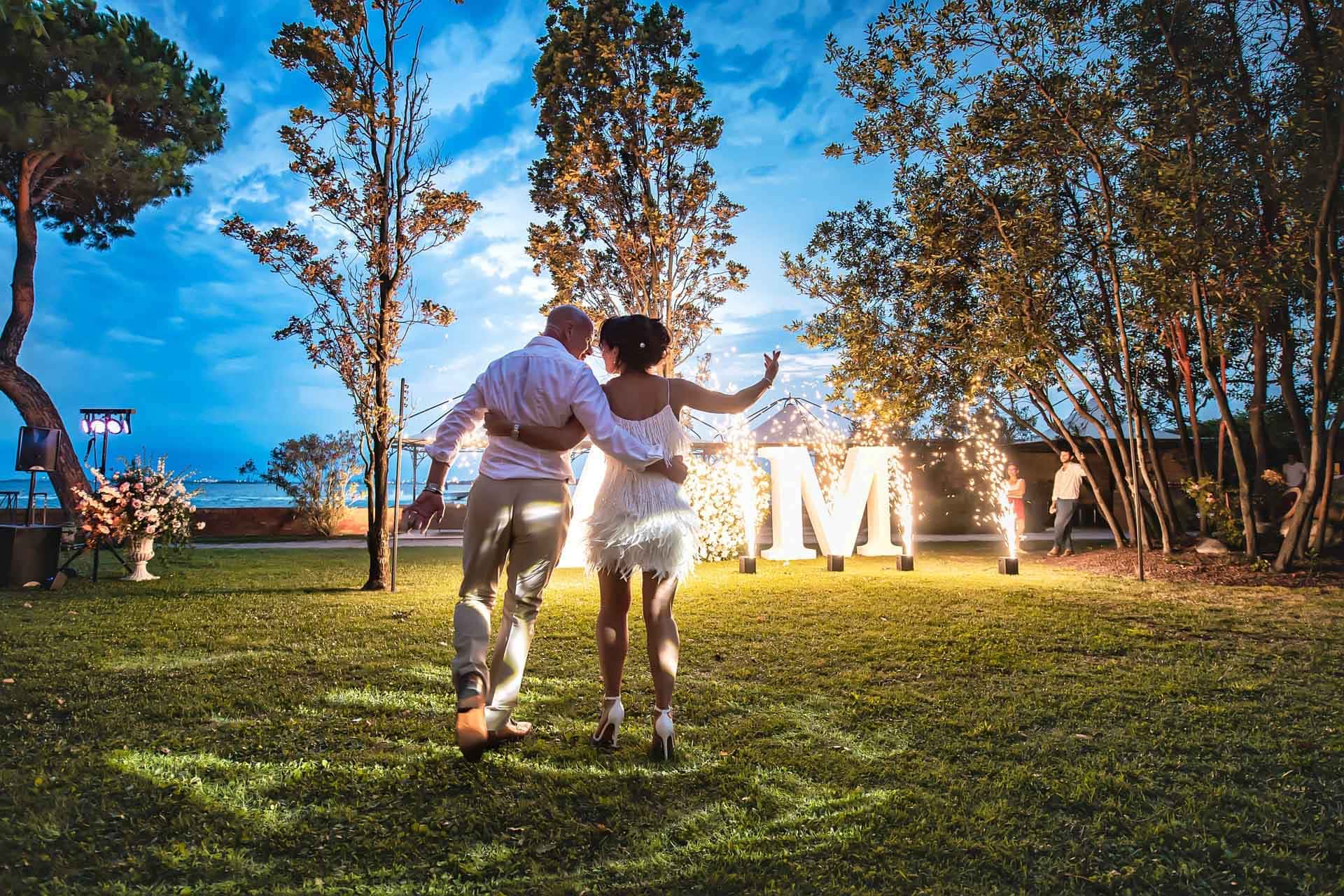 Venice wedding celebration with dancing and fairy lights at sunset.