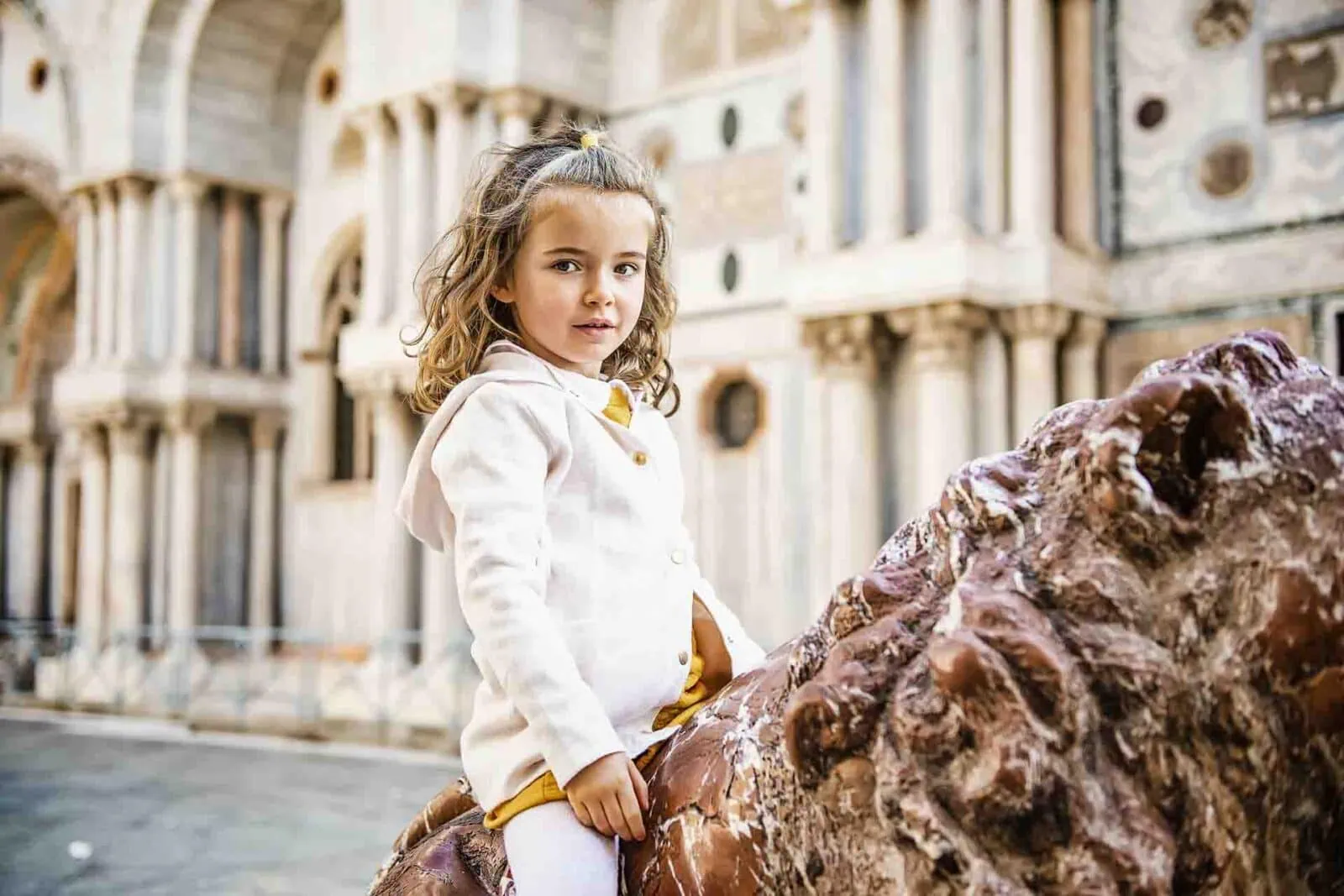 Mother and daughter sharing a sweet moment on a charming Venetian bridge.
