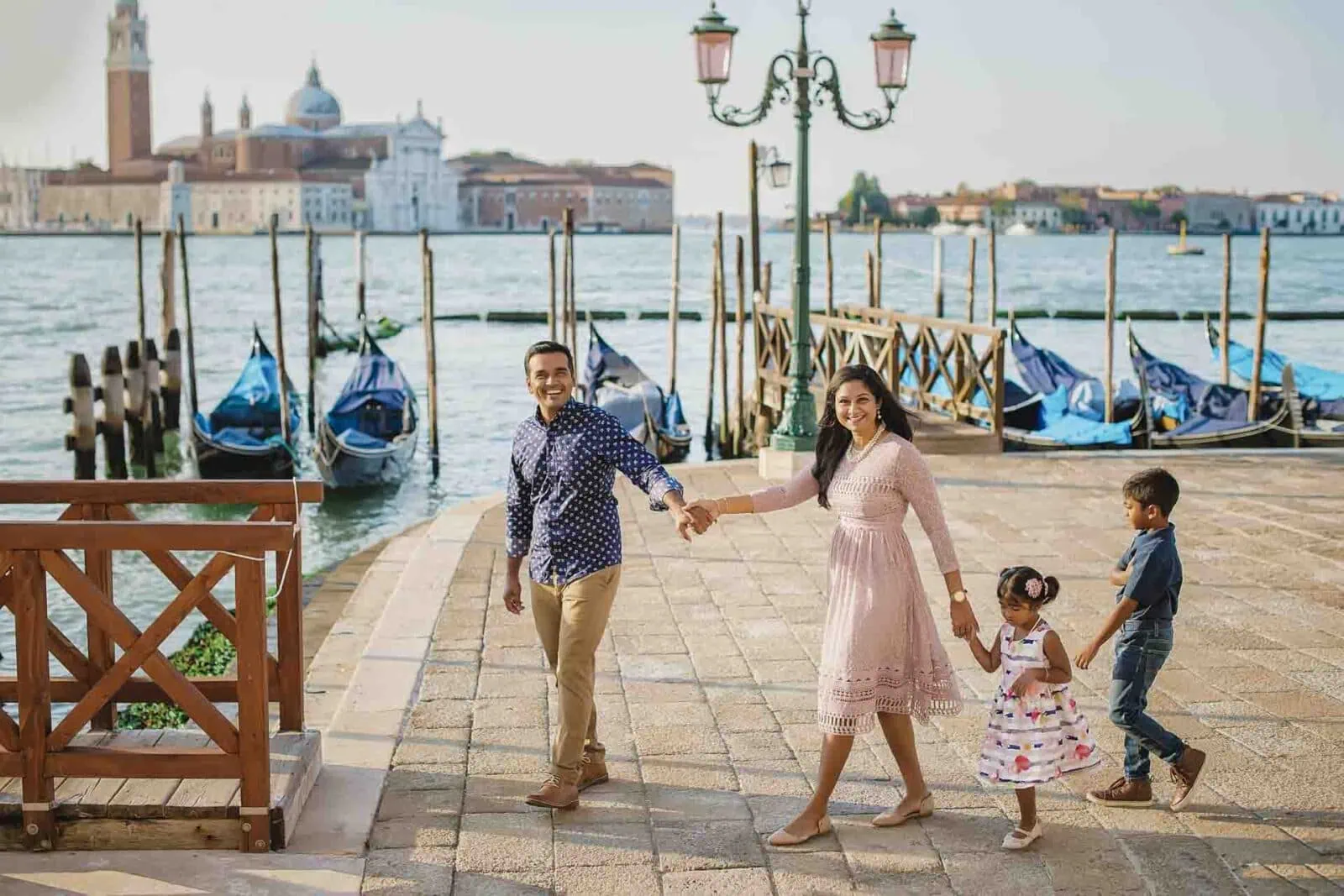 A family standing by the Grand Canal, enjoying the stunning Venice skyline.