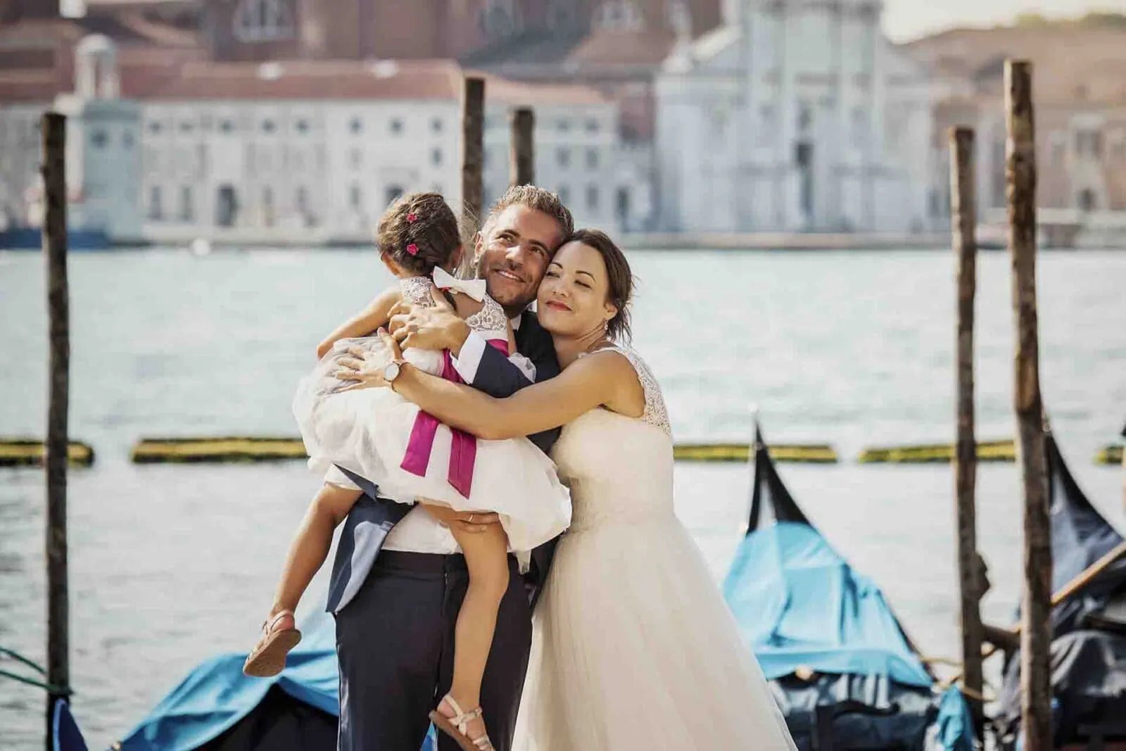 A family standing by the Grand Canal, enjoying the stunning Venice skyline.