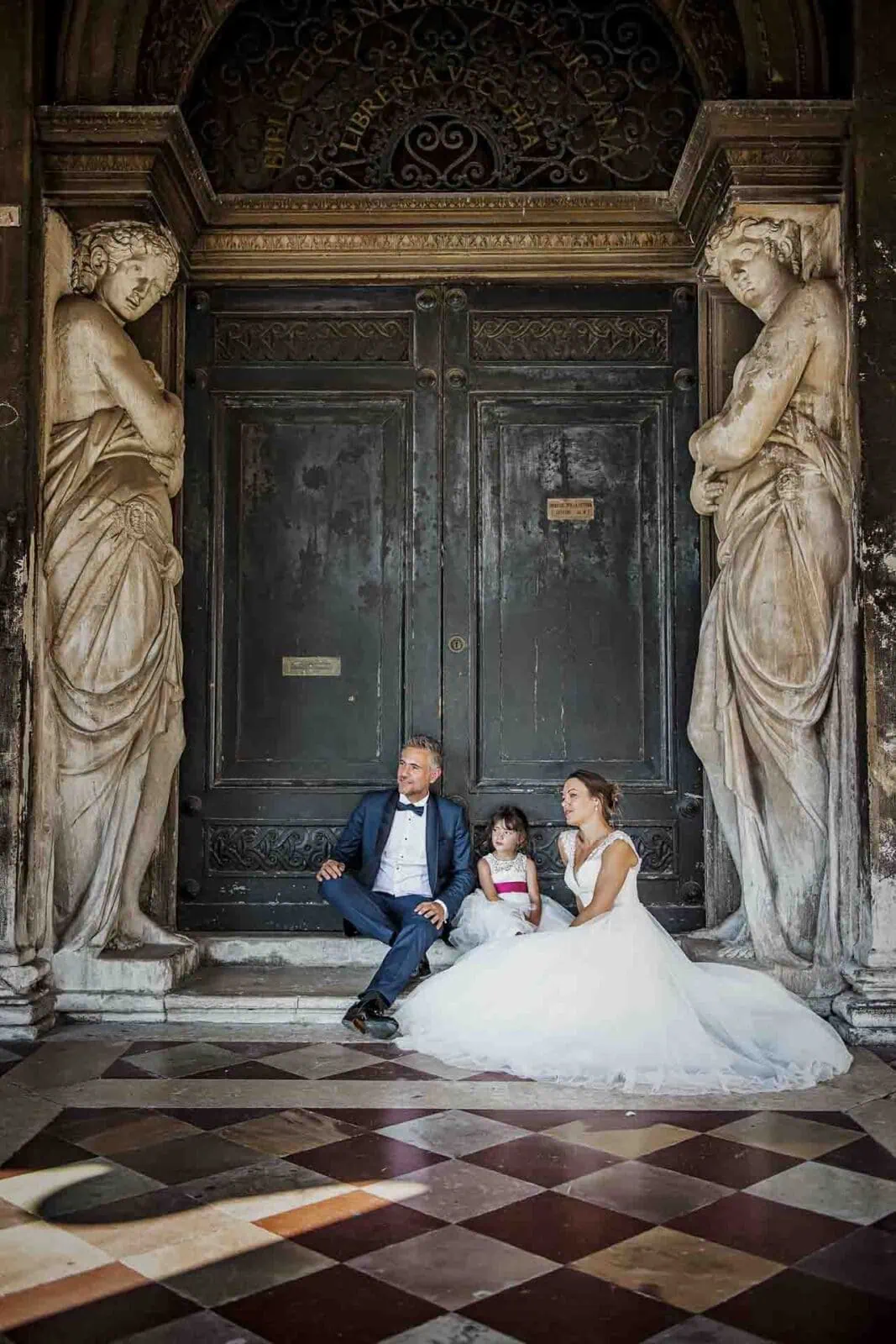 Parents with their daughter under the historic porticoes of the Doge’s Palace in Venice.
