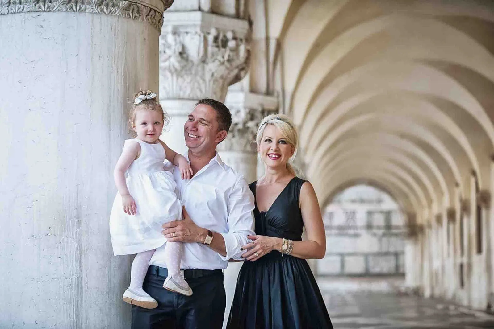 Parents with their daughter under the historic porticoes of the Doge’s Palace in Venice.