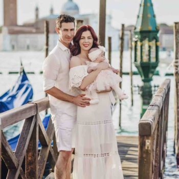 A family standing by the Grand Canal, enjoying the stunning Venice skyline.