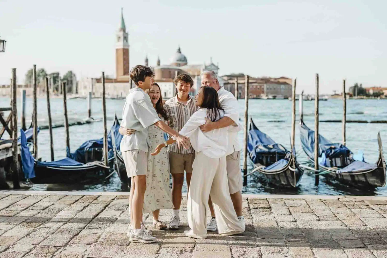 A family standing by the Grand Canal, enjoying the stunning Venice skyline.