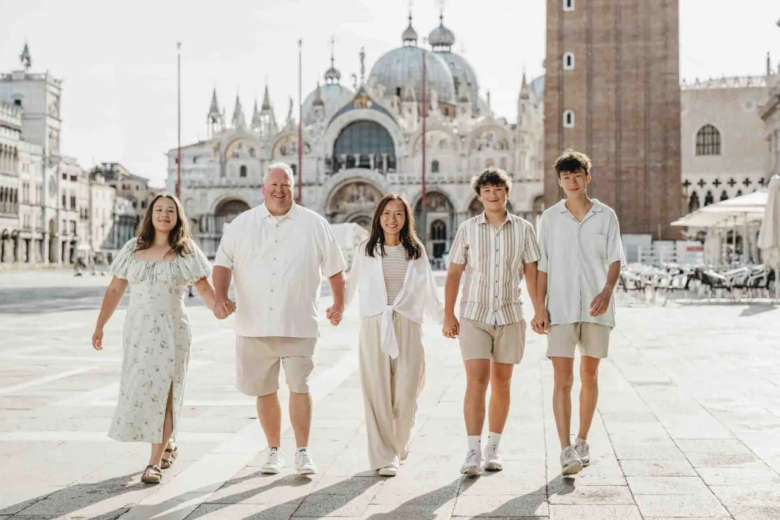 A happy family posing in St. Mark’s Square, Venice, with the Basilica in the background.