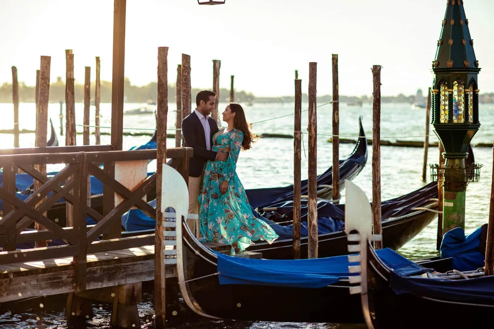 Engagement photos in Venice with a couple embracing by the Grand Canal at sunset.