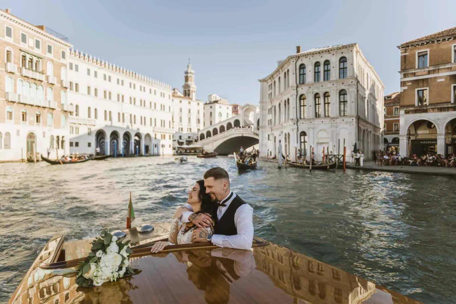 Romantic couple enjoying their honeymoon in Venice, Italy, captured in a scenic Venetian backdrop with historic canals, gondolas, and iconic landmarks.