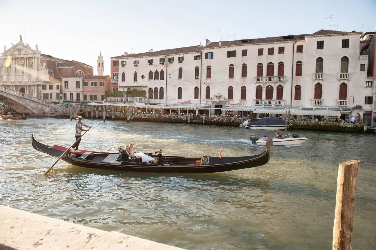 Romantic couple enjoying their honeymoon in Venice, Italy, captured in a scenic Venetian backdrop with historic canals, gondolas, and iconic landmarks.
