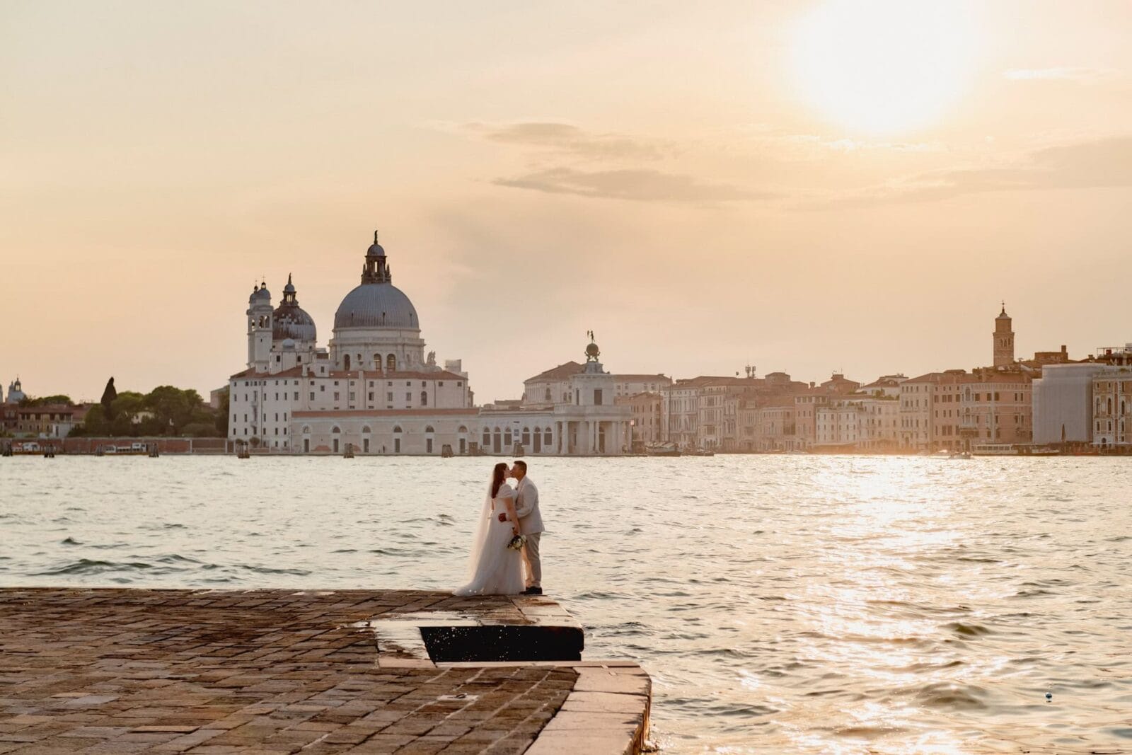 Romantic couple enjoying their honeymoon in Venice, Italy, captured in a scenic Venetian backdrop with historic canals, gondolas, and iconic landmarks.