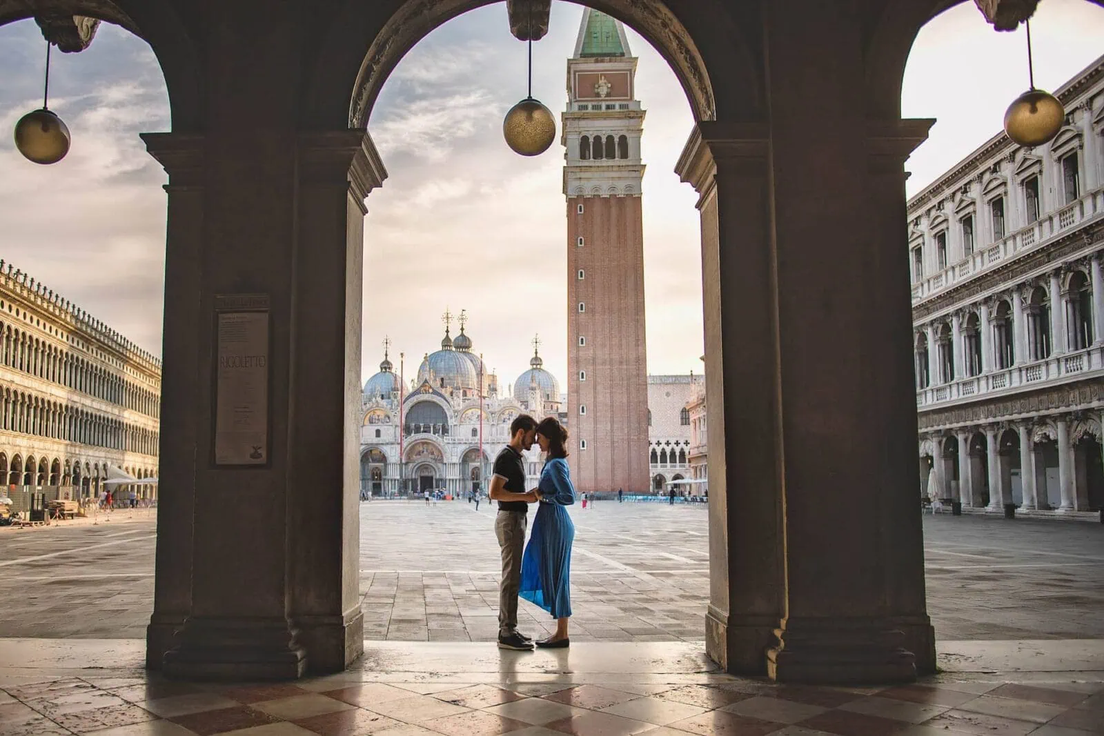 Engagement photos in Venice featuring a couple touching foreheads with Piazza San Marco in the background.