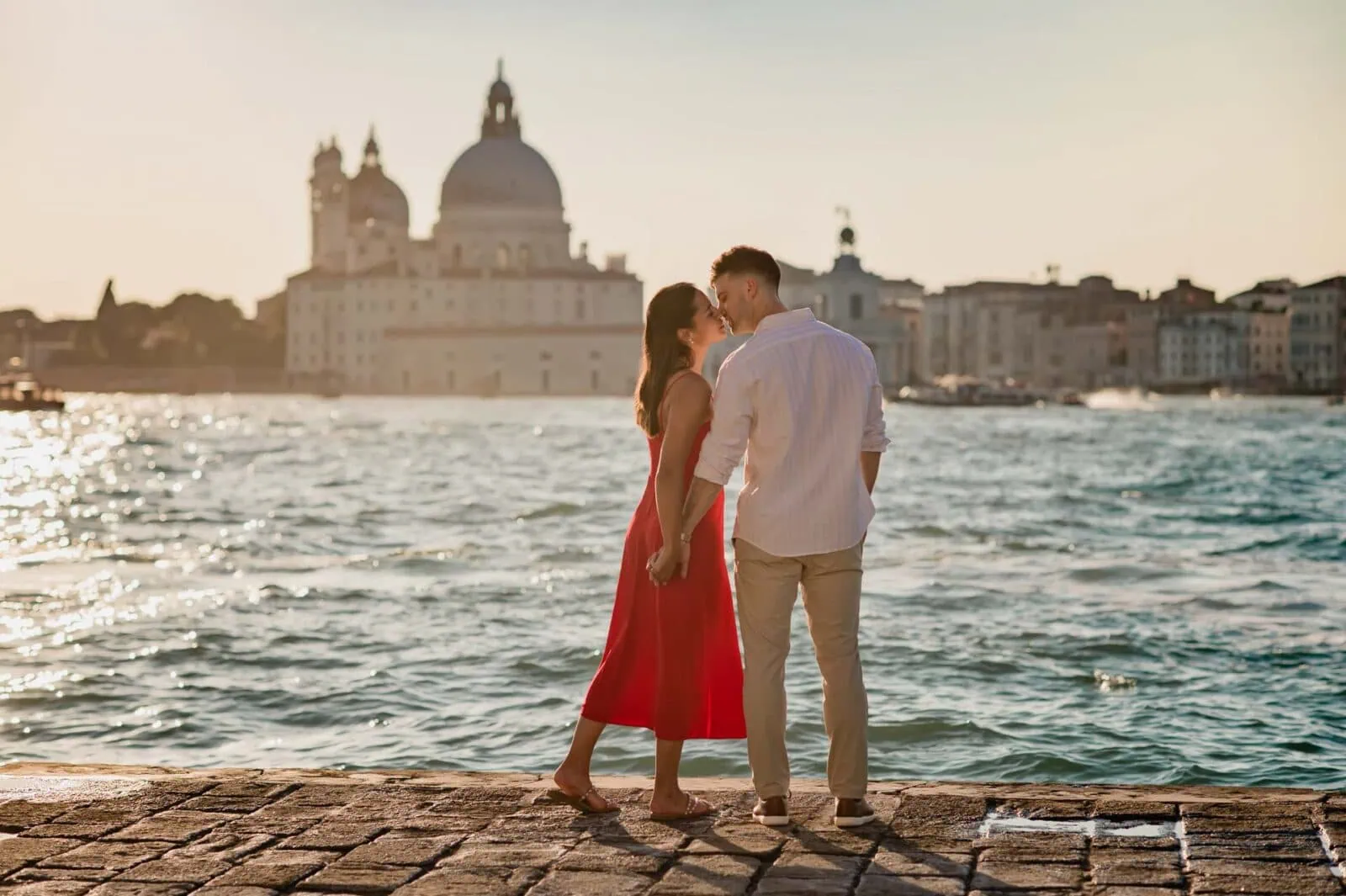 A couple kissing at San Giorgio Maggiore during sunset in their engagement photoshoot in Venice.