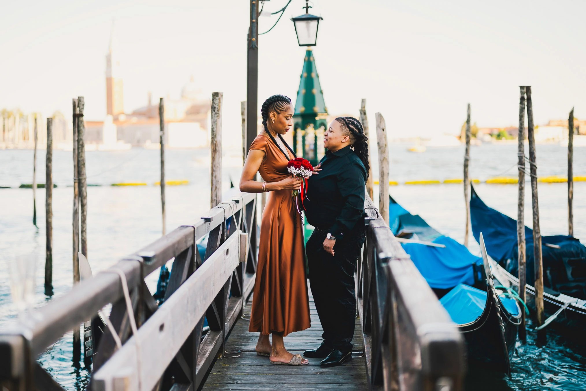 Lesbian couple walking along Riva dei Schiavoni with Grand Canal view in Venice