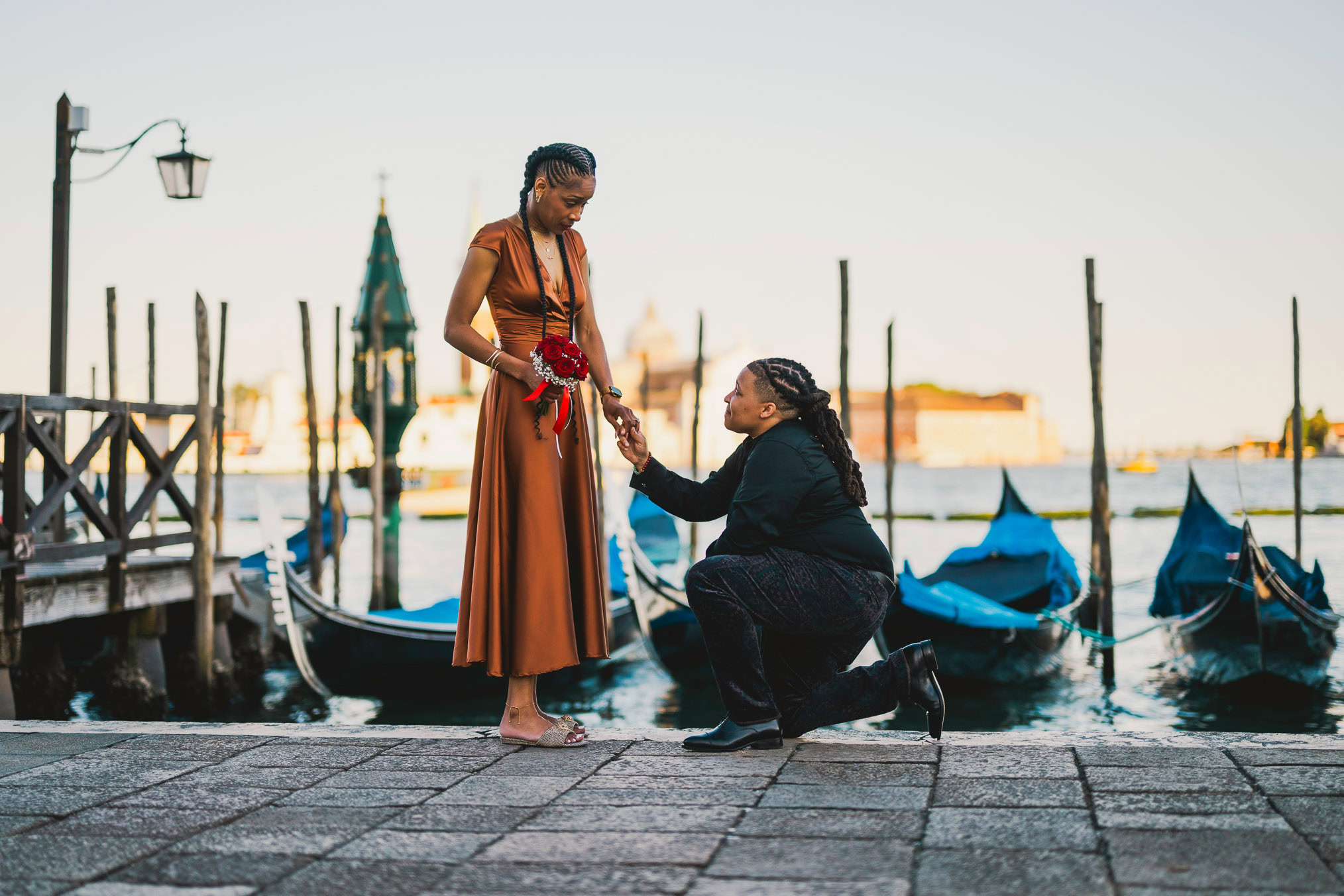 Lesbian couple walking along Riva dei Schiavoni with Grand Canal view in Venice