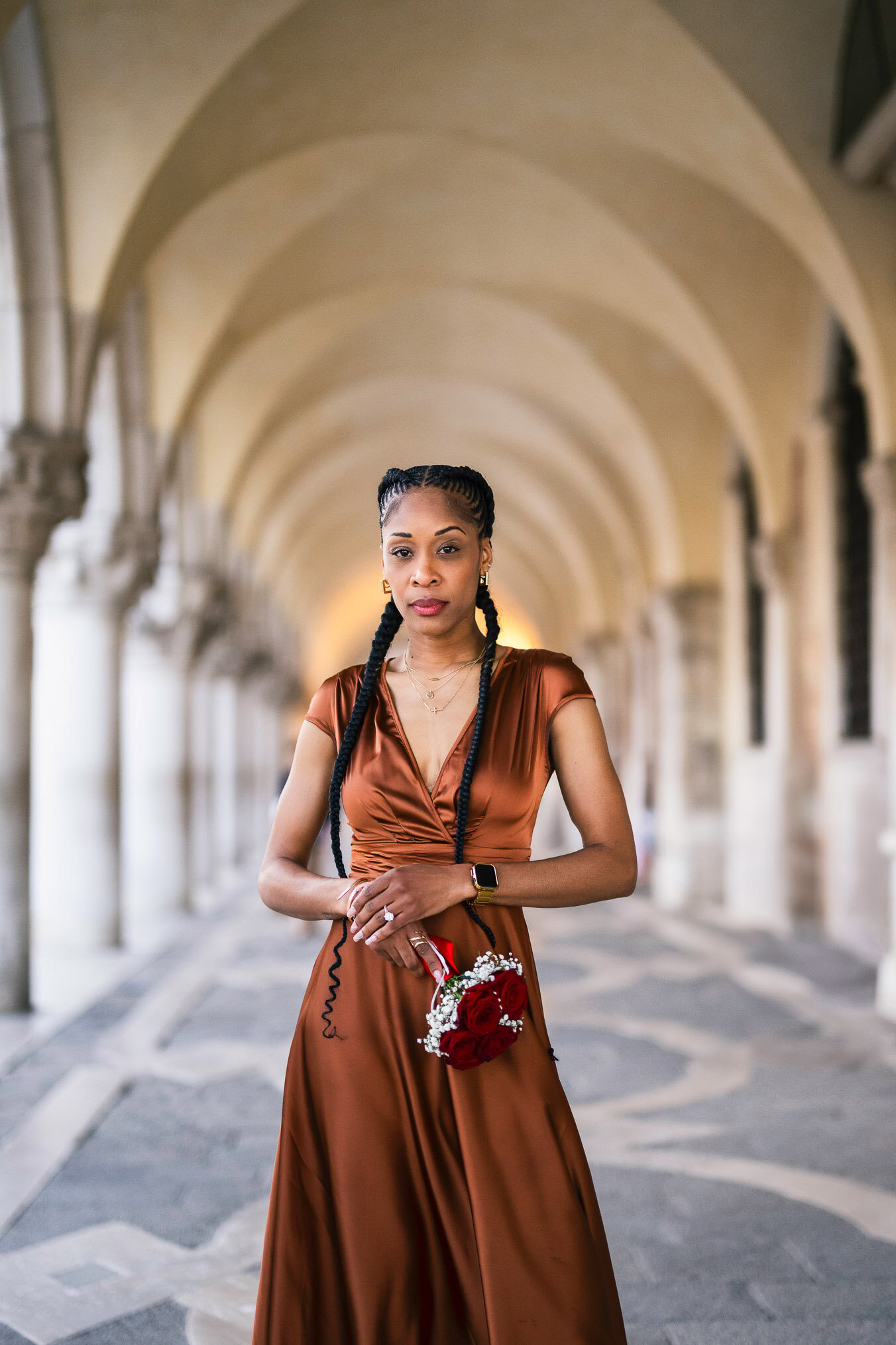 Two women in love under the arcades of San Marco with Bridge of Sighs behind them