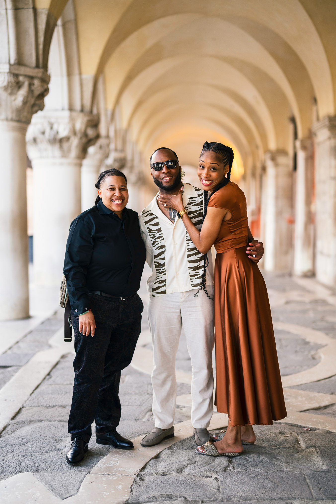 Two women in love under the arcades of San Marco with Bridge of Sighs behind them