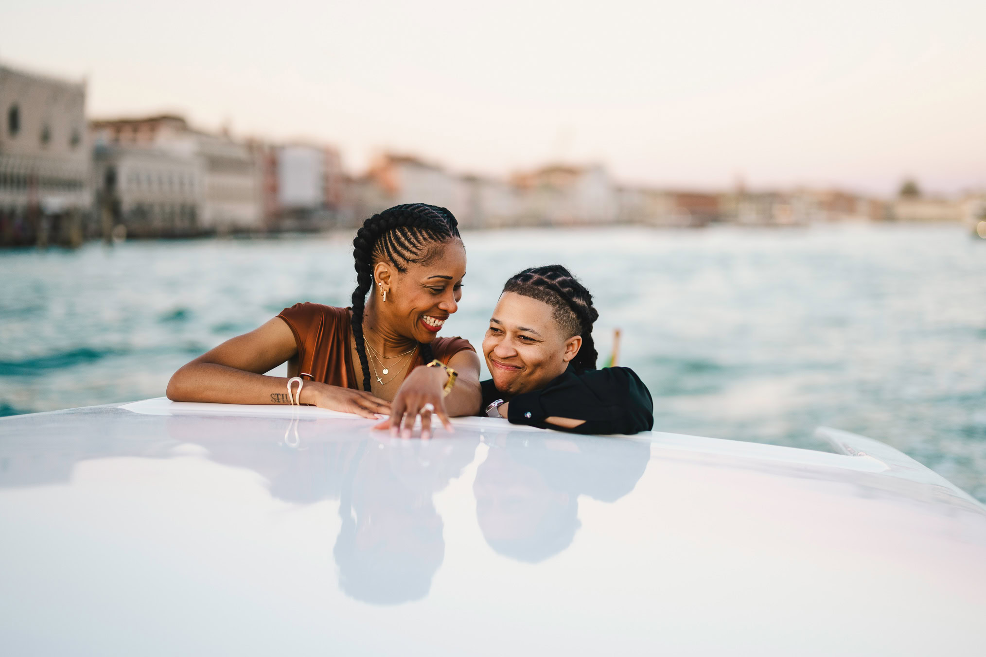 Lesbian couple in a private water taxi on the Grand Canal during their proposal in Venice