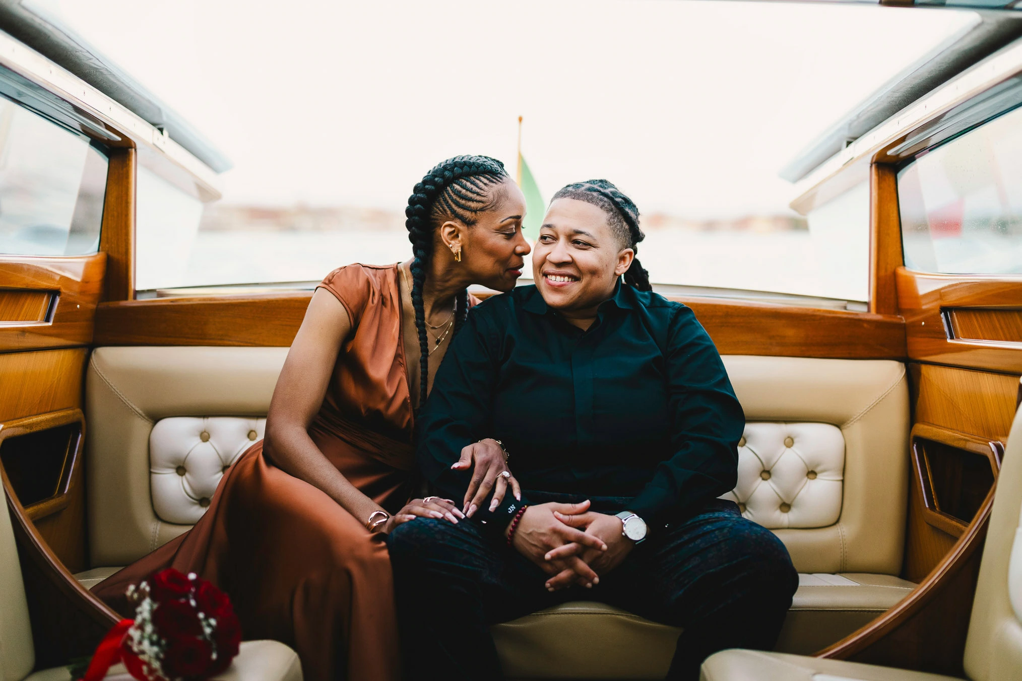 Lesbian couple in a private water taxi on the Grand Canal during their proposal in Venice