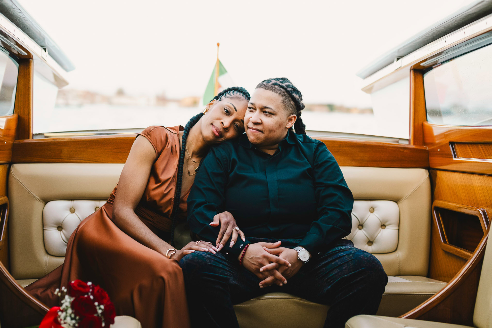 Lesbian couple in a private water taxi on the Grand Canal during their proposal in Venice