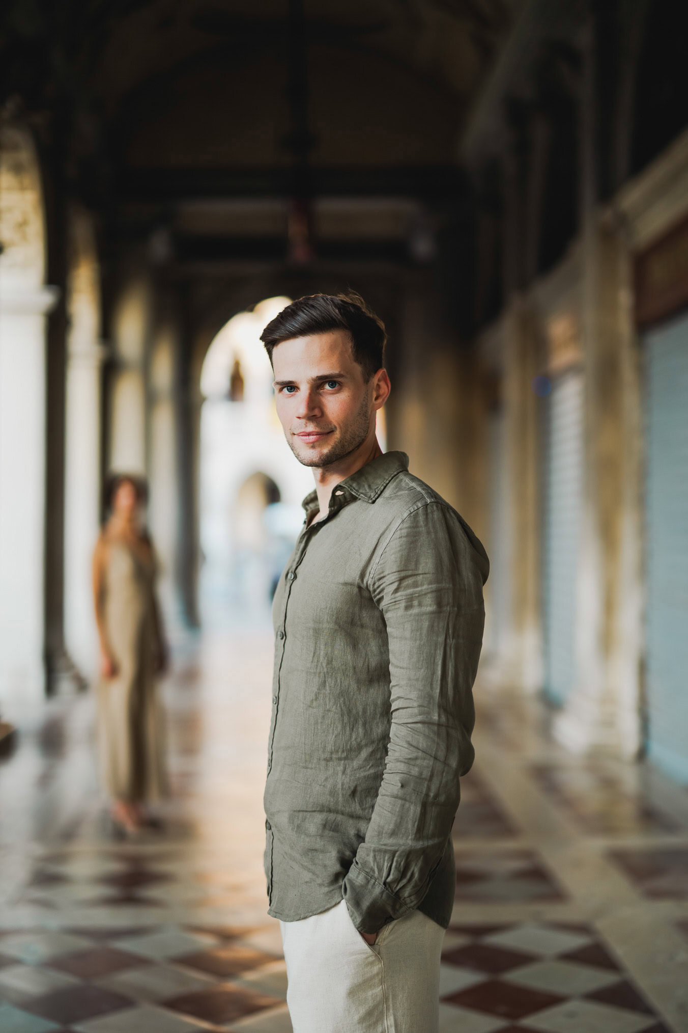 Engaged couple standing under the historic arches of San Marco