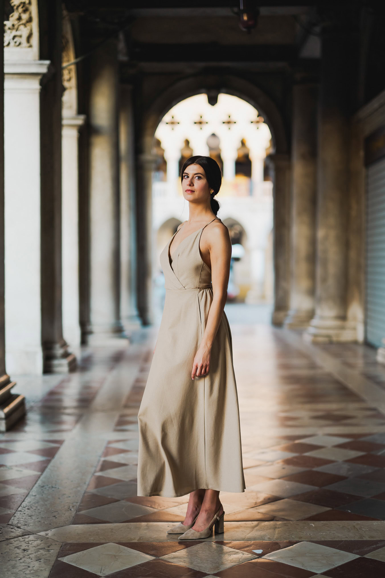 Engaged couple standing under the historic arches of San Marco
