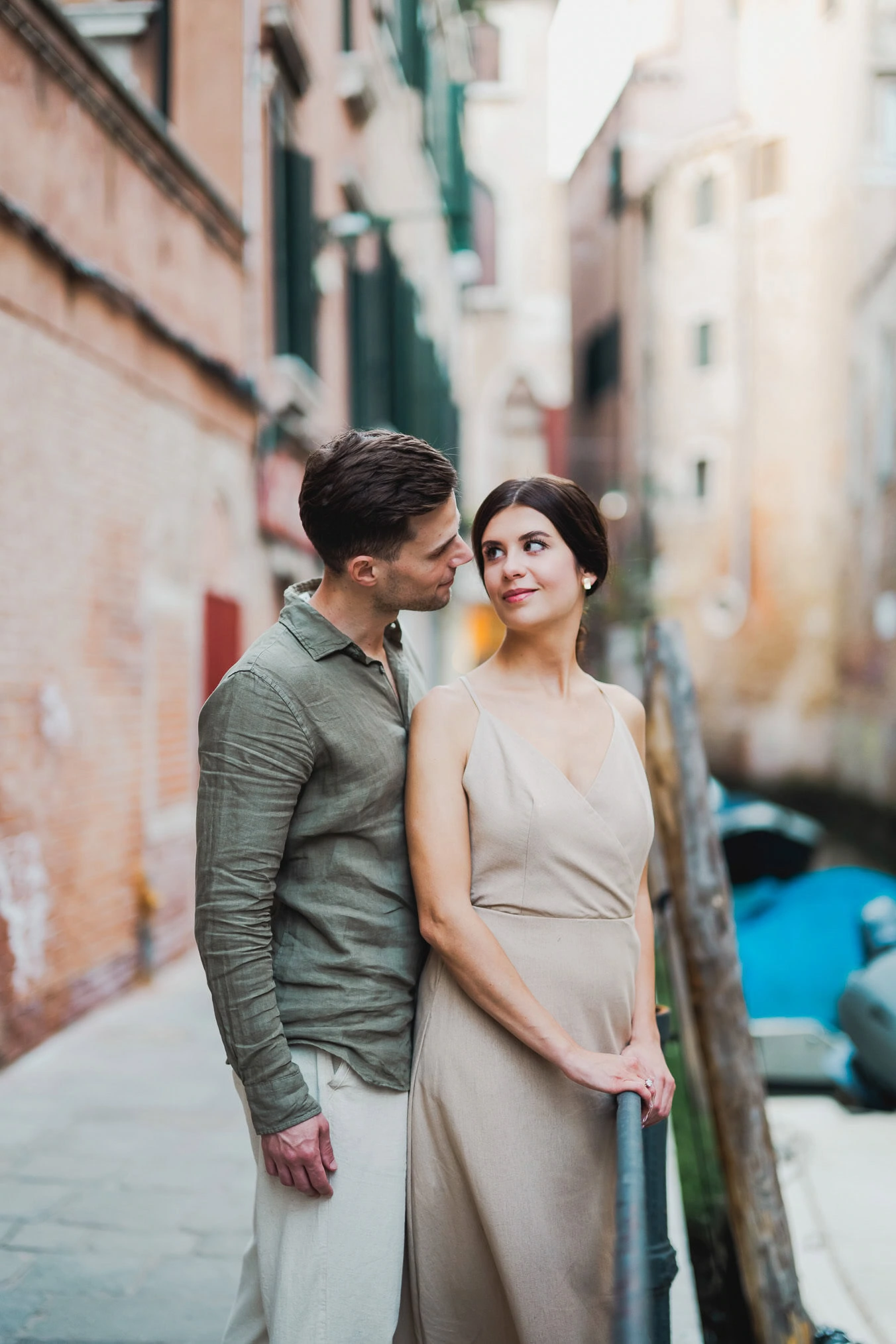 Couple sharing a private moment beside a Venetian canal
