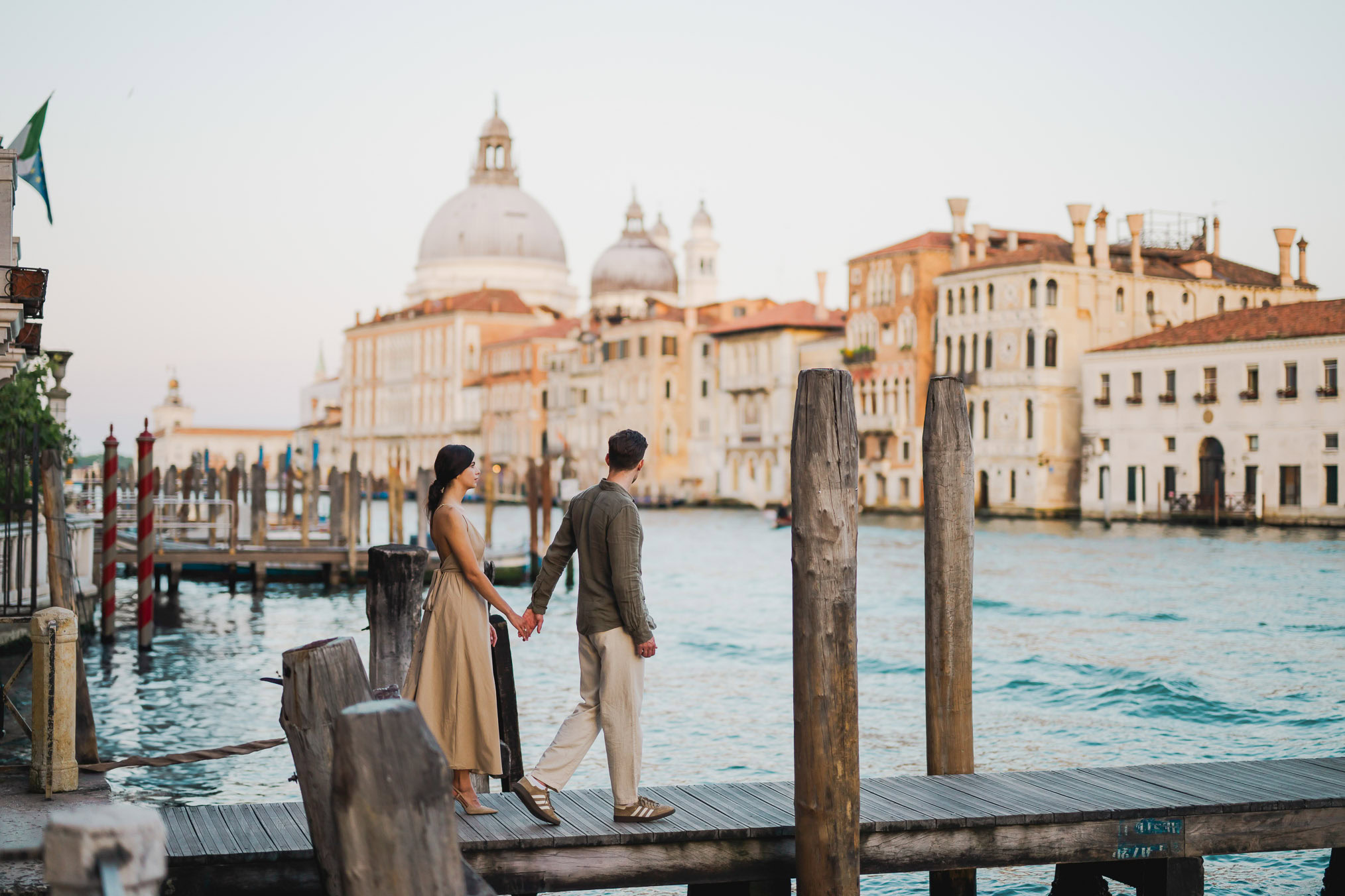 Couple sitting beside a Venetian canal during engagement shoot
