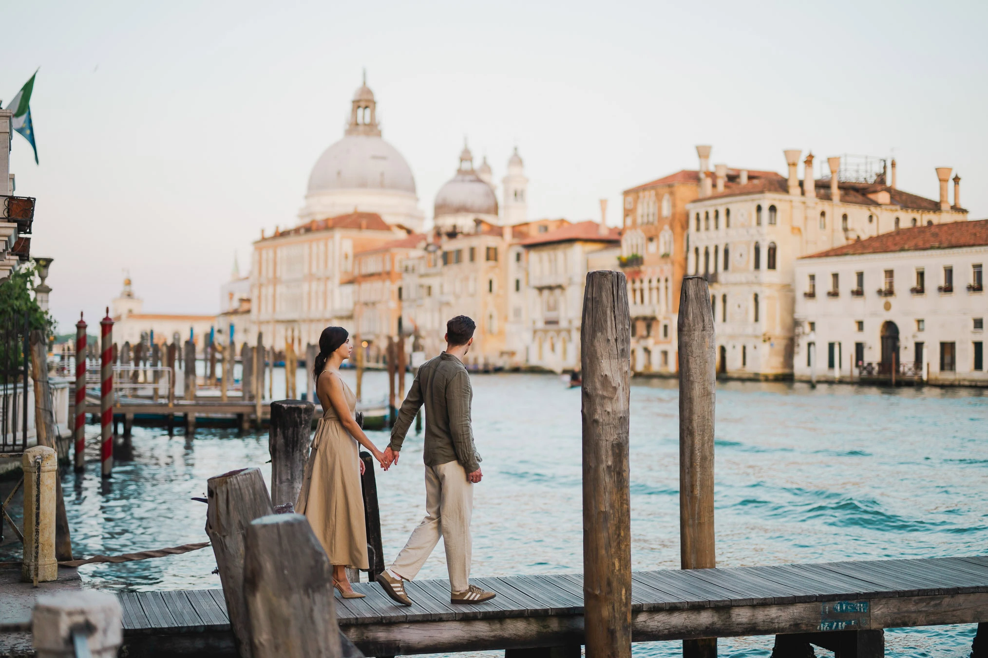Couple sitting beside a Venetian canal during engagement shoot