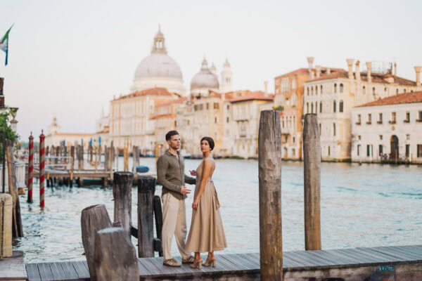 Couple sitting beside a Venetian canal during engagement shoot