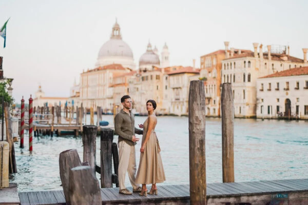 Couple sitting beside a Venetian canal during engagement shoot
