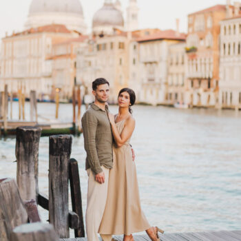 Couple sitting beside a Venetian canal during engagement shoot