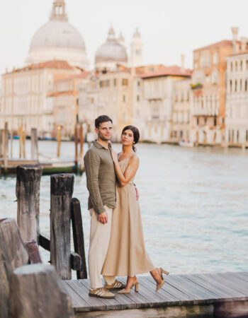 Couple sitting beside a Venetian canal during engagement shoot