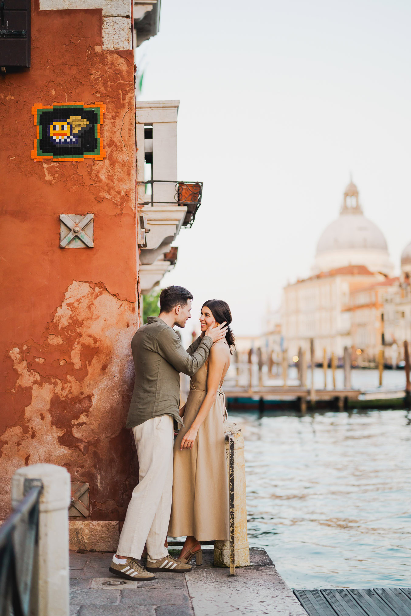 Couple gazing into each other's eyes under Venice's evening lights
