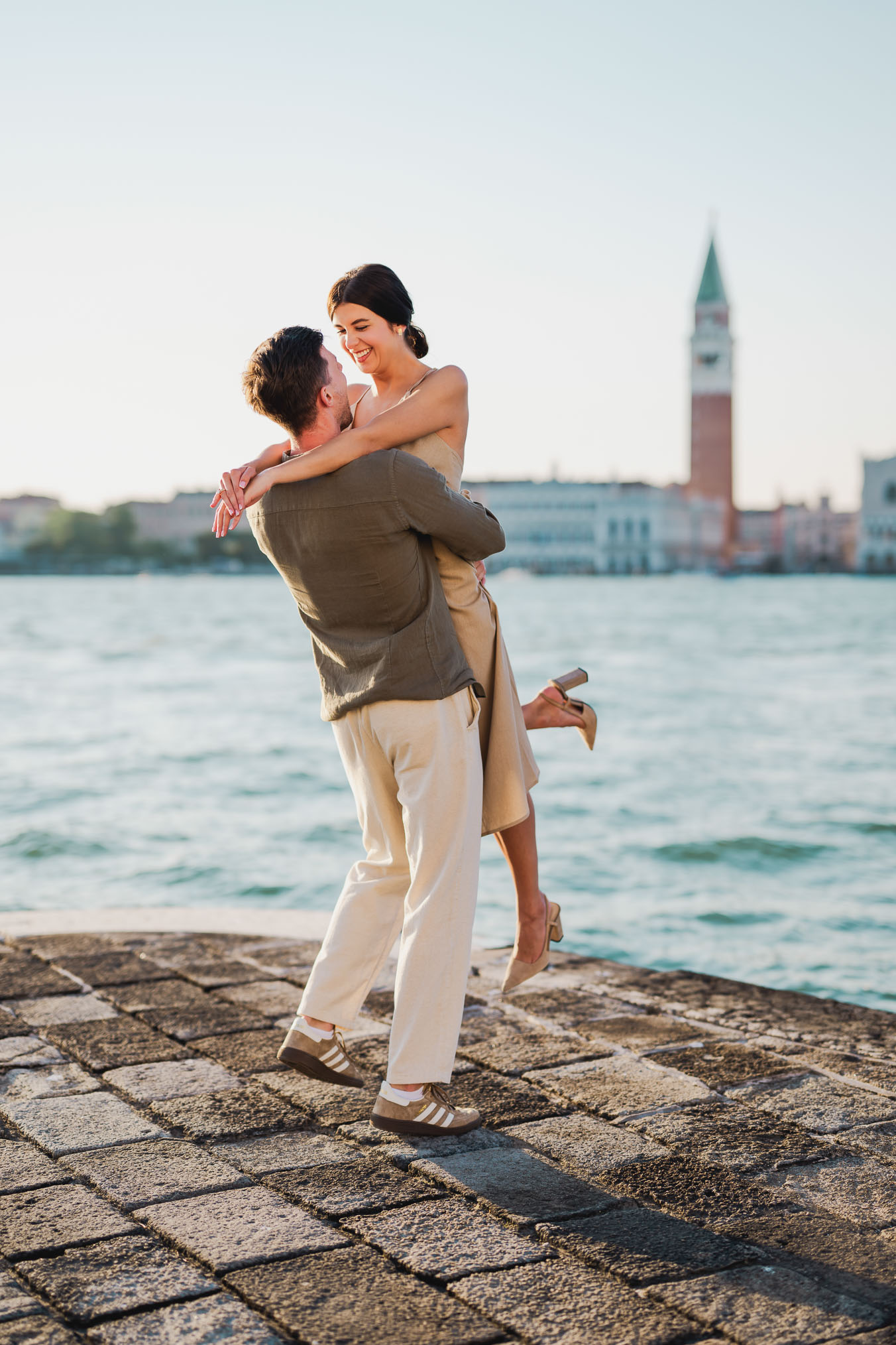 Couple embracing joyfully after engagement in Venice
