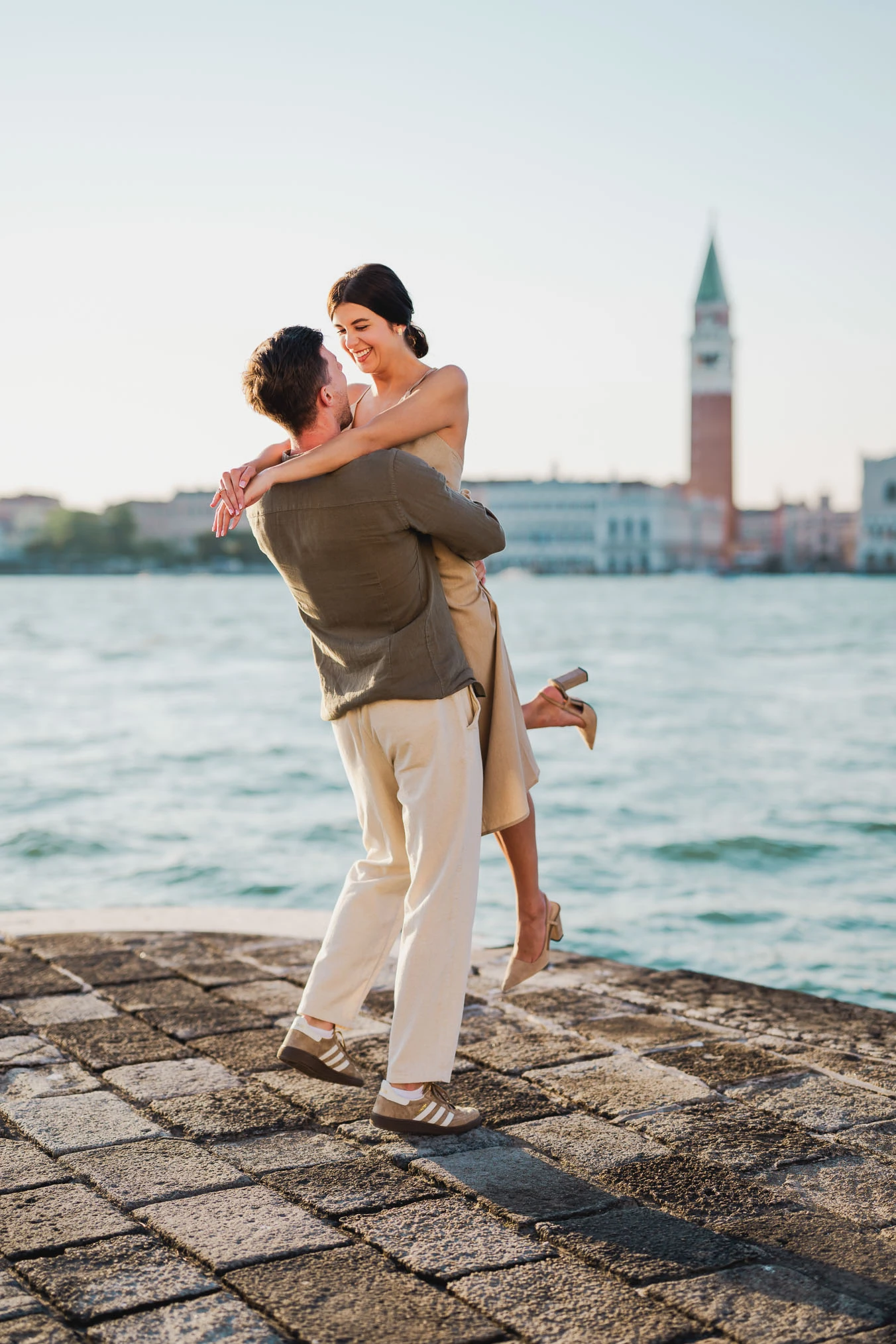 Couple embracing joyfully after engagement in Venice