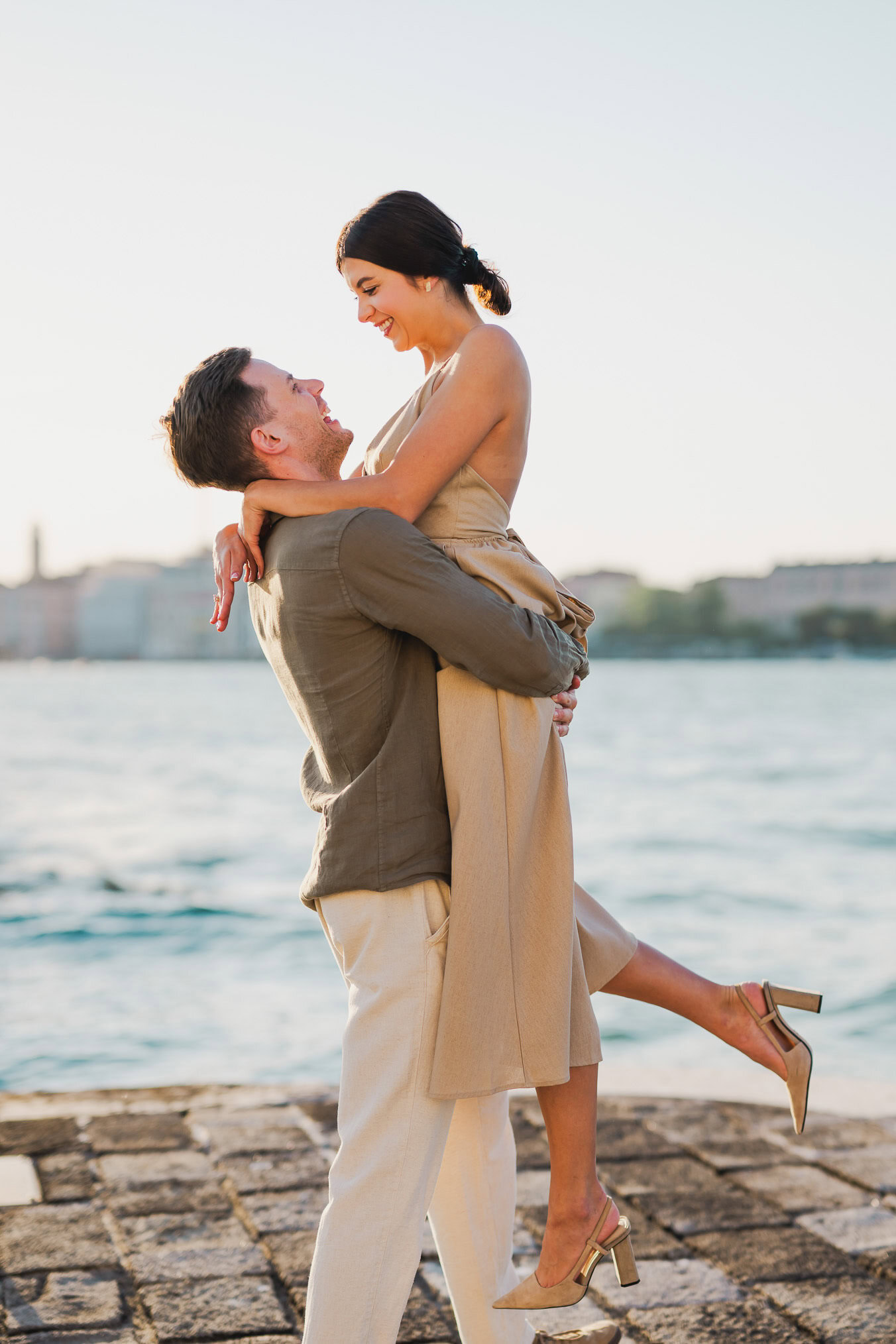 Couple embracing joyfully after engagement in Venice