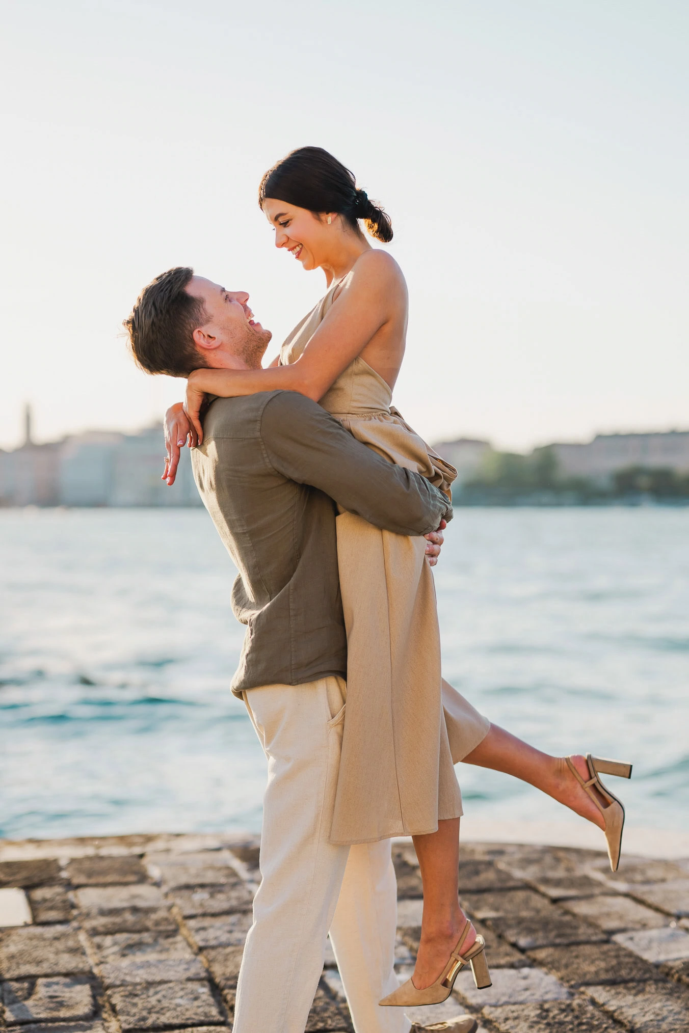 Couple embracing joyfully after engagement in Venice