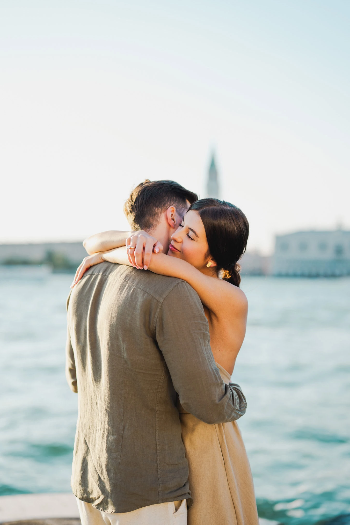 Couple embracing joyfully after engagement in Venice