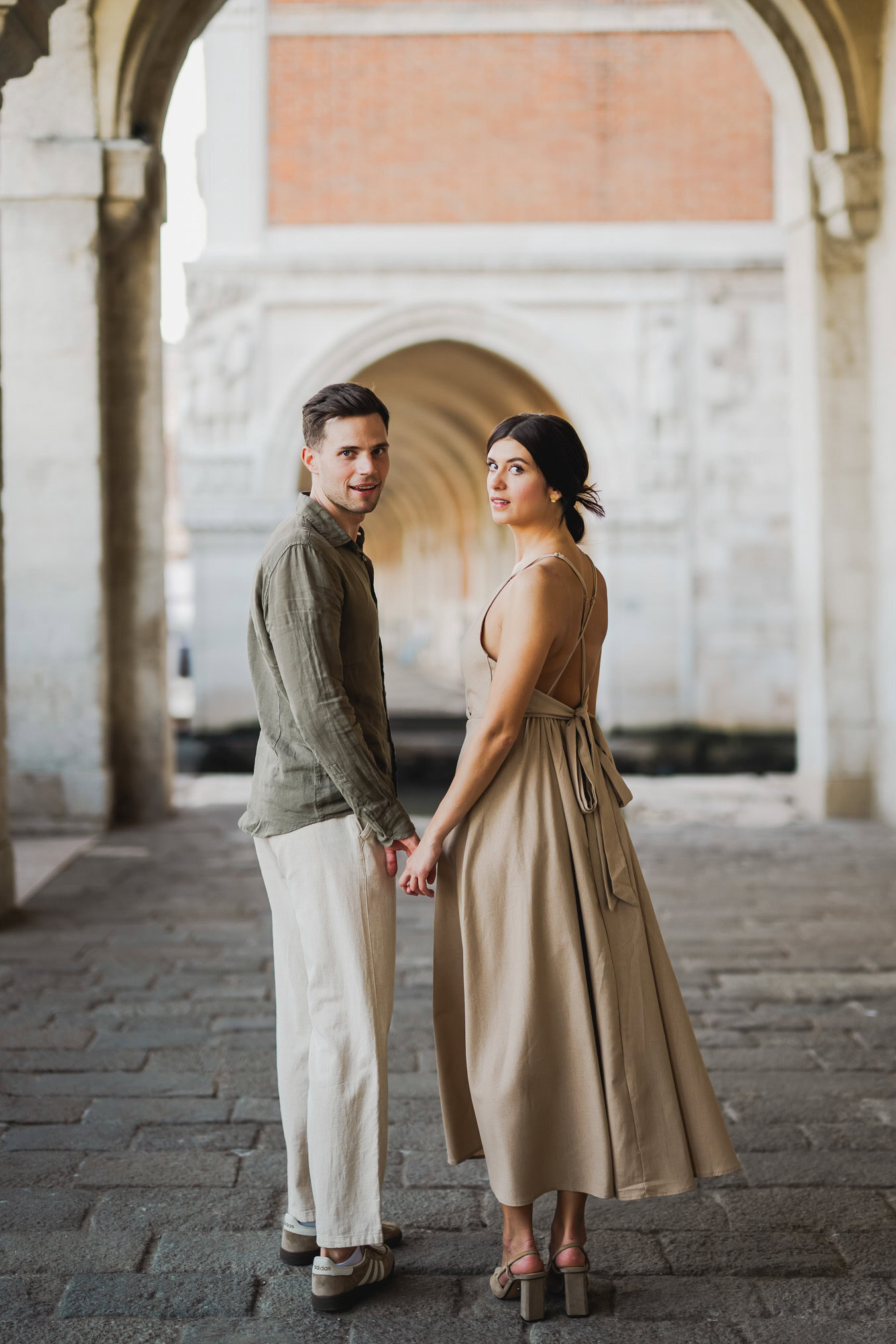 Engaged couple walking hand in hand through San Marco district