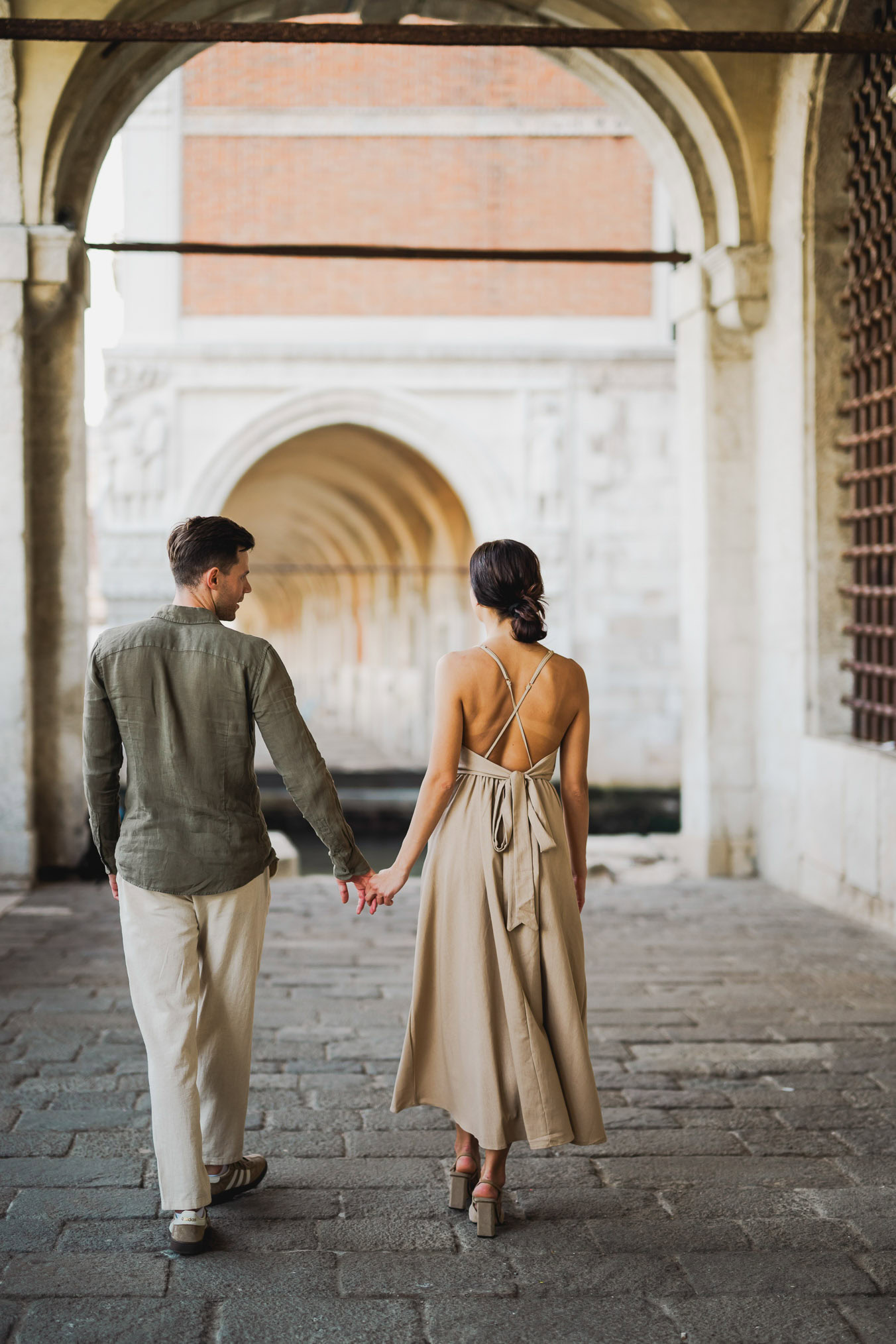Engaged couple walking hand in hand through San Marco district