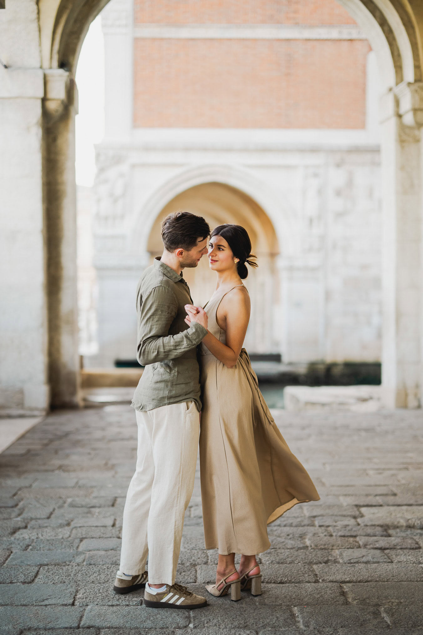 Engaged couple walking hand in hand through San Marco district
