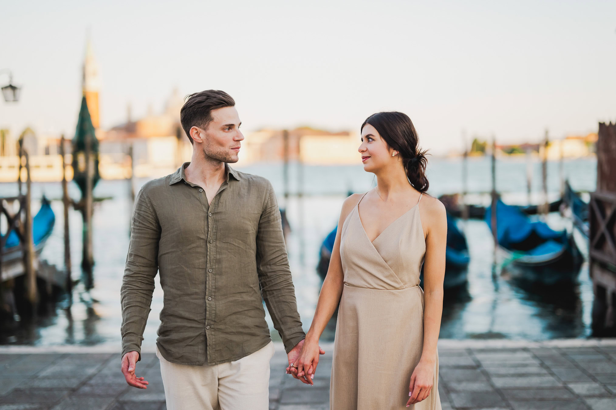 Engaged couple walking hand in hand through San Marco district