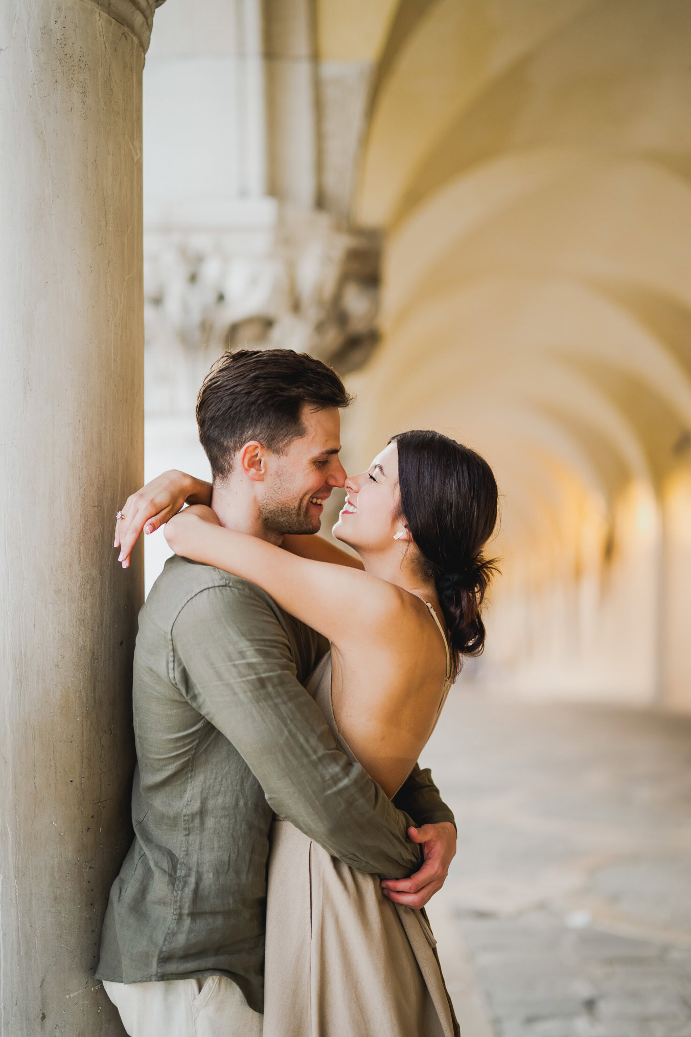 Engaged couple standing under the historic arches of San Marco