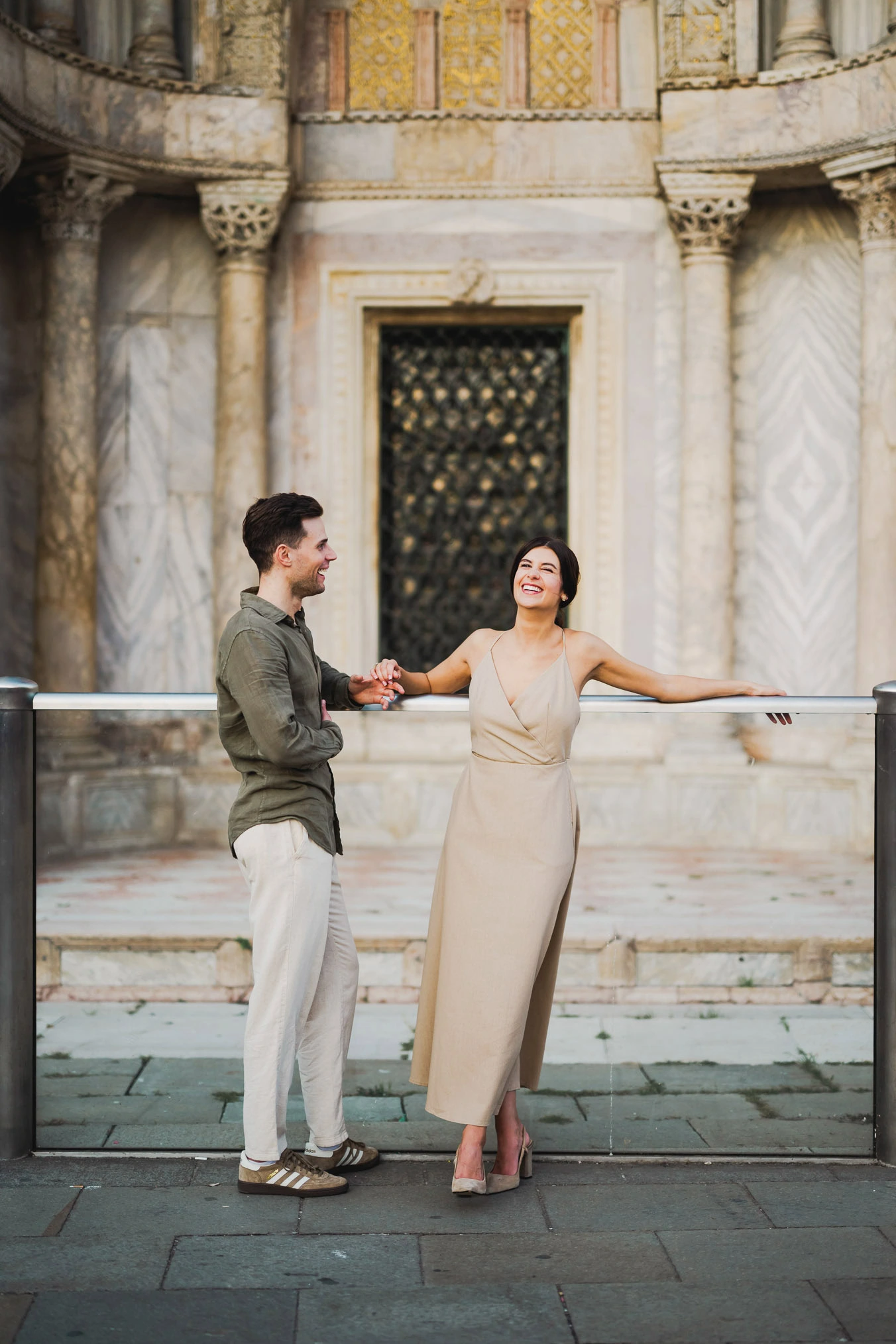 Engaged couple standing under the historic arches of San Marco