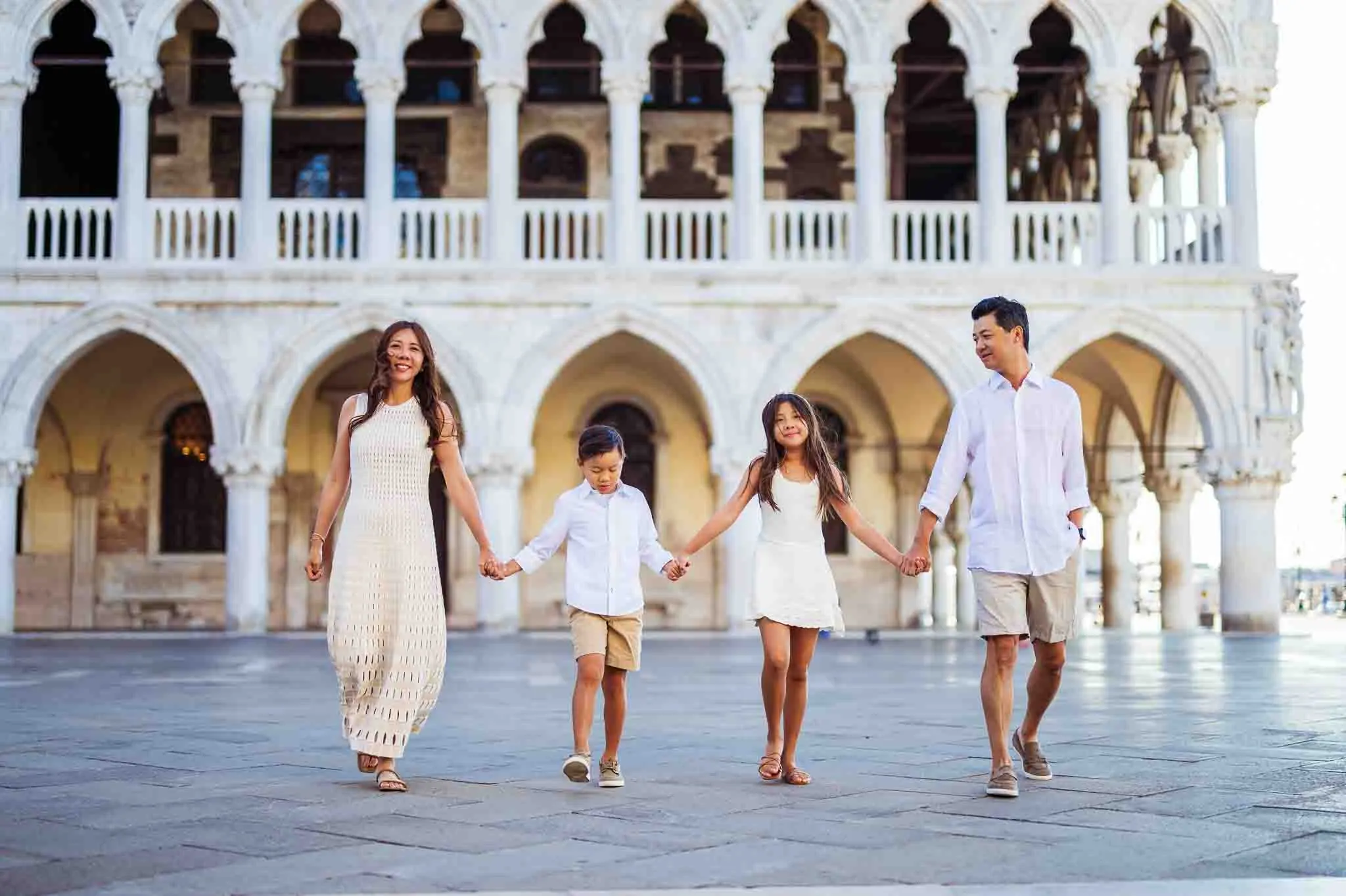 Elegant family portrait in Venice, capturing joyful moments at historic architecture.