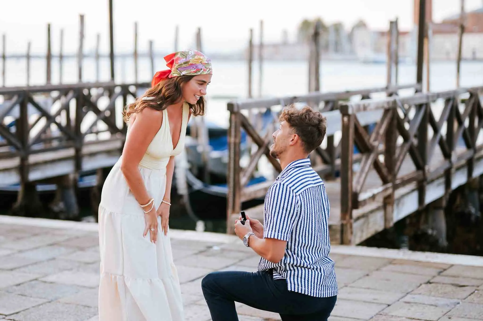 Romantic Venice proposal at sunset with a man proposing to his partner by the canal.
