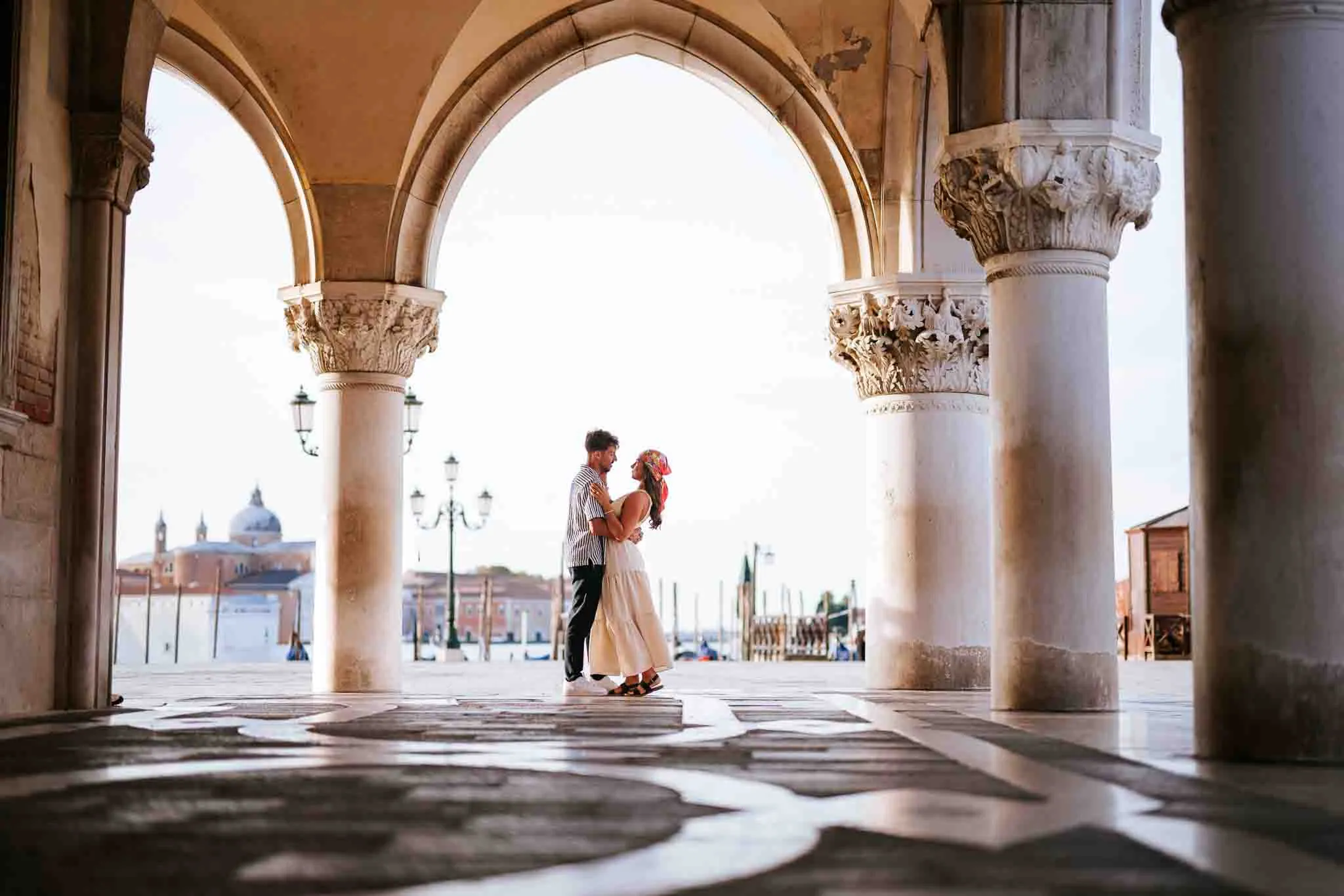 1. Romantic couple dance beneath Venetian arches in Venice, capturing engagement moments.