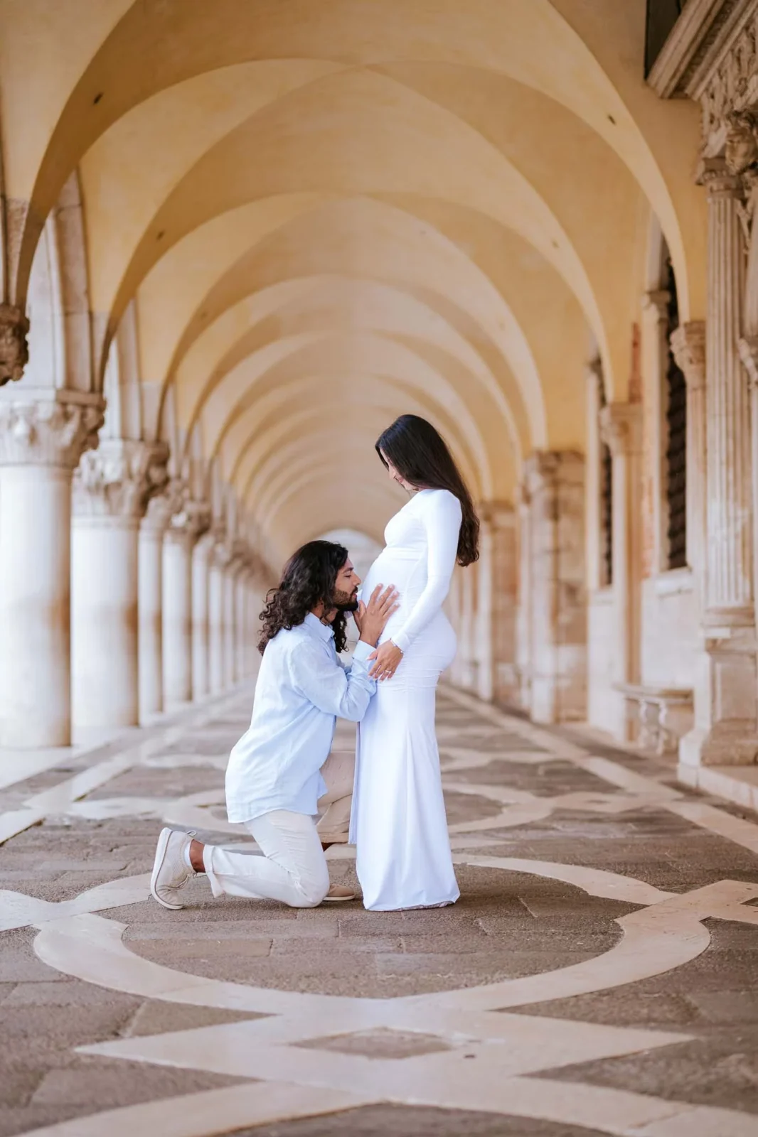 1. Romantic couple maternity photoshoot in Venice's historic archways and columns.