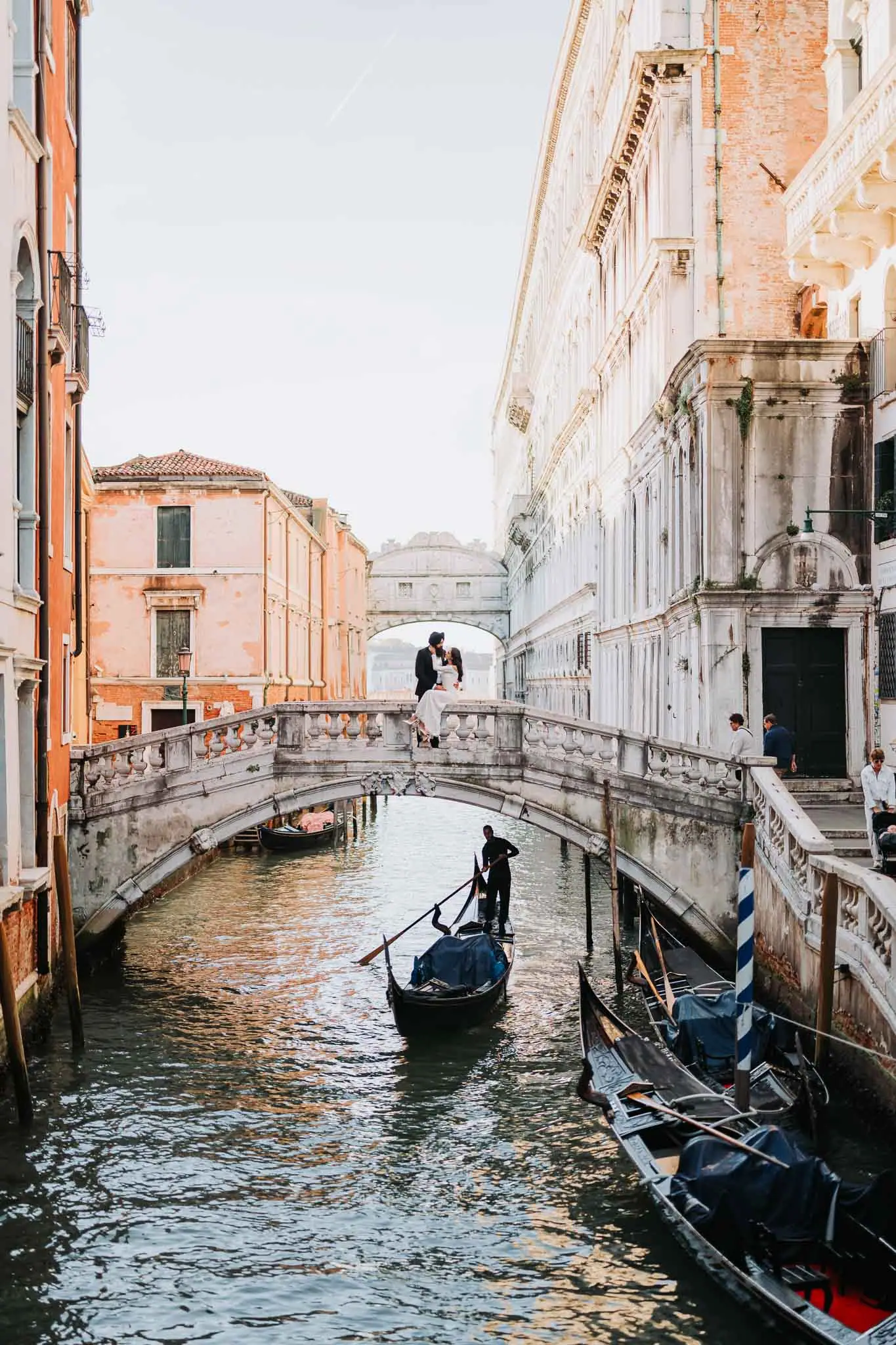 Romantic couple on a Venice gondola bridge, stunning architecture and canals, perfect for wedding and engagement photos.